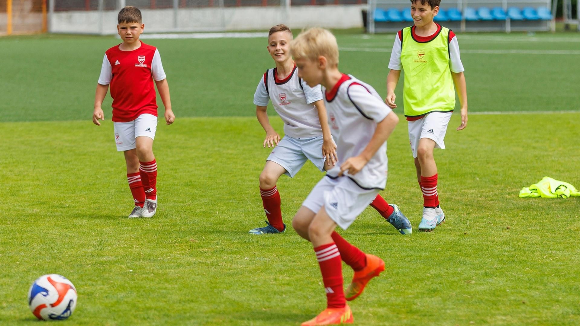 Četvero dječaka igra nogomet na travnatom terenu na Falkensteiner Resort Punta Skala