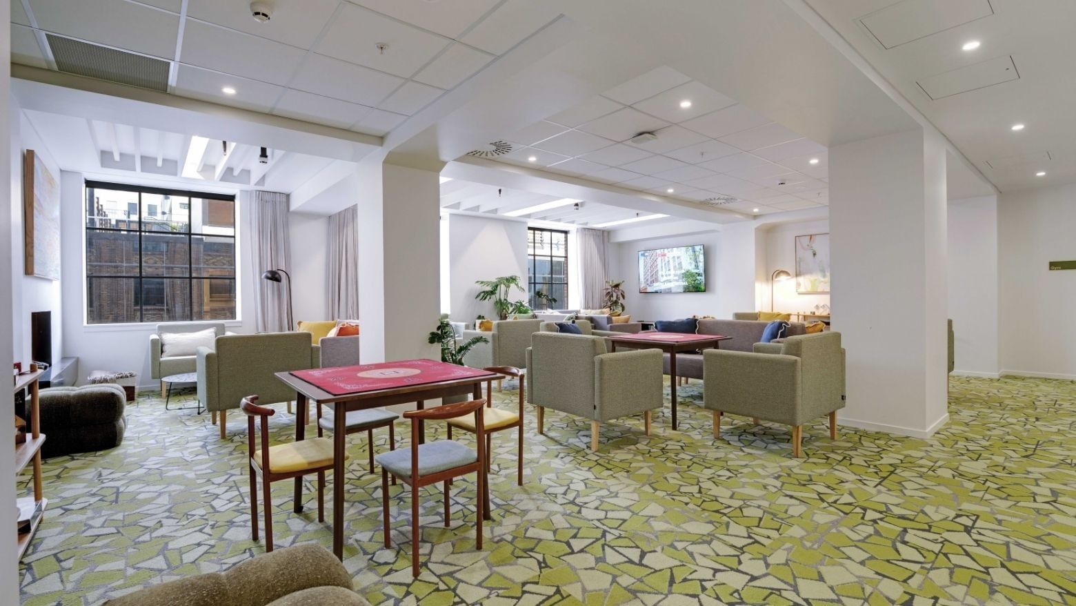 Modern communal lounge with game tables, seating areas, and natural light at UniLodge Auckland Central.