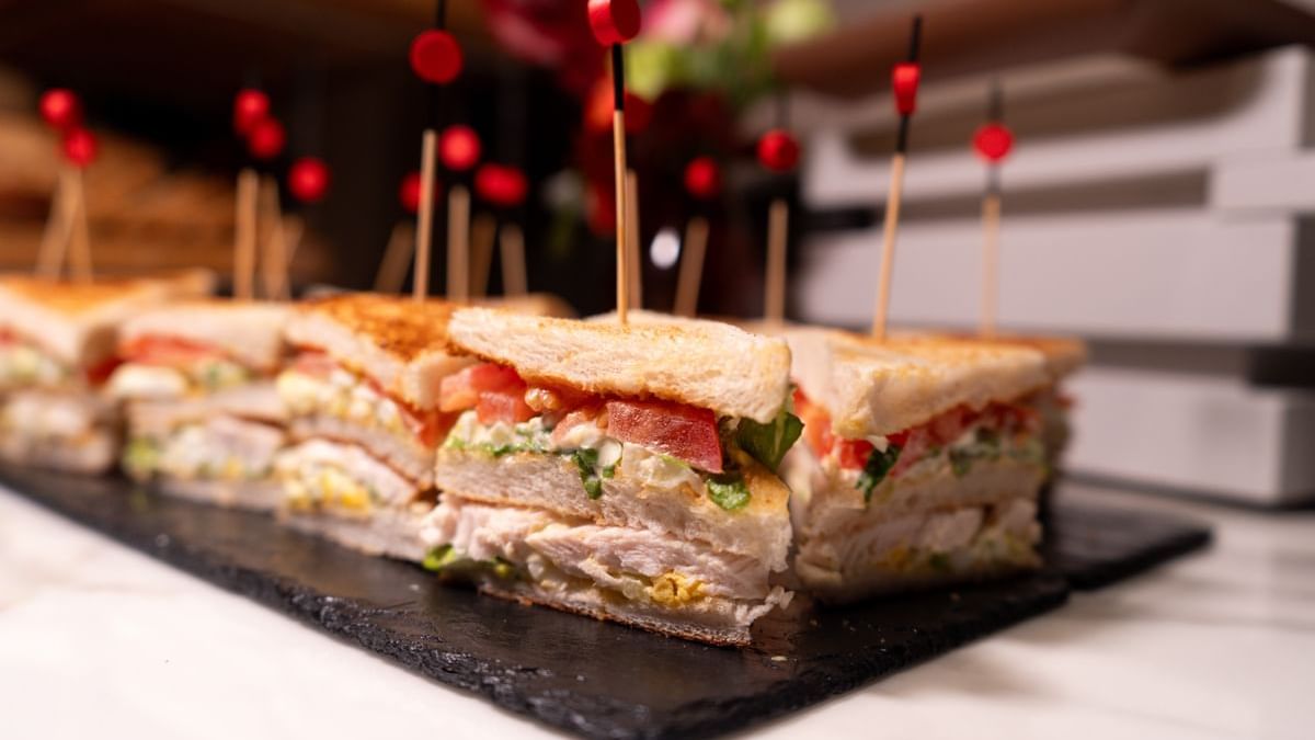 Close-up of club sandwich cut into portions with toothpicks on a slate board at Warwick Paris Champs Elysées