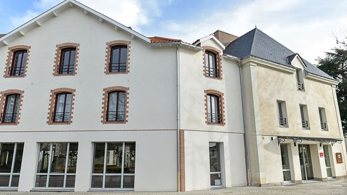 Façade moderne de l'Hôtel Rivella avec de nombreuses fenêtres et entrées vitrées.