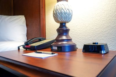 A desk with a lamp, phone, and notepad in a room at Rosen Inn Lake Buena Vista