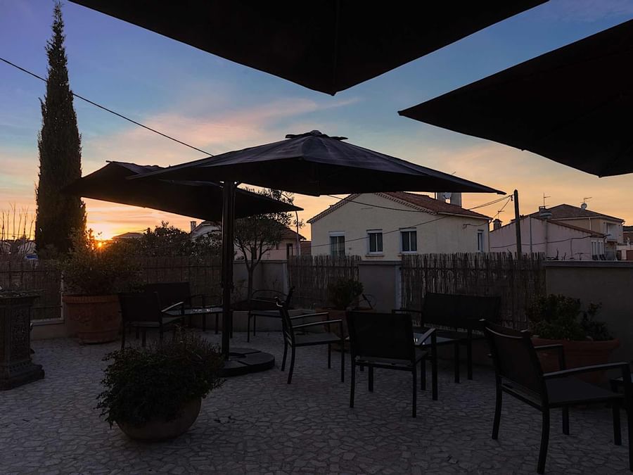 An outdoor dining area at sunset in Clair Hotel