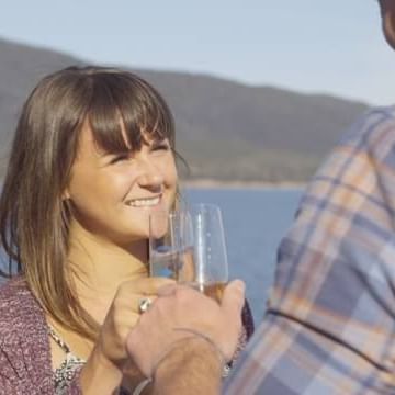 A couple having champagne at the Bay in Freycinet Lodge