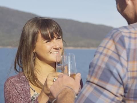 A couple having champagne at the Bay in Freycinet Lodge