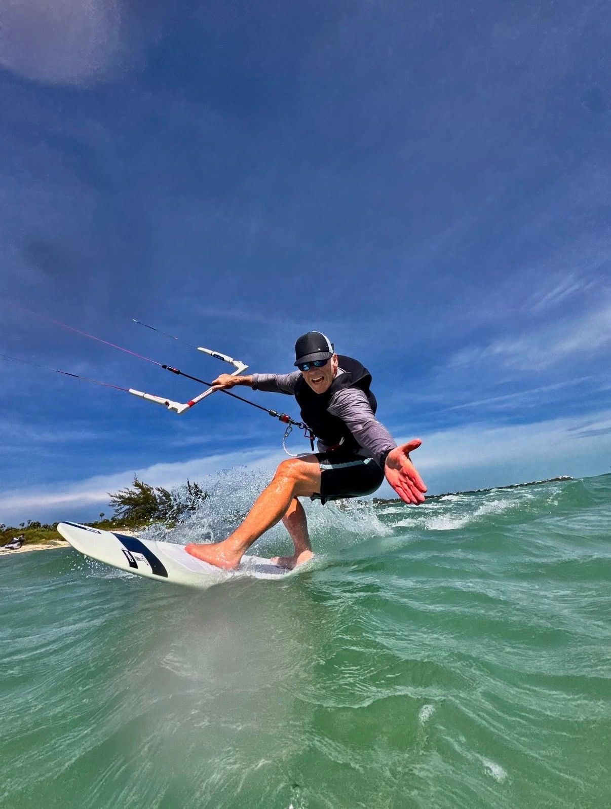 Kitesurfer carving through shallow turquoise water at Long Bay Beach