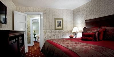 guest room with bed, media stand and table lamp