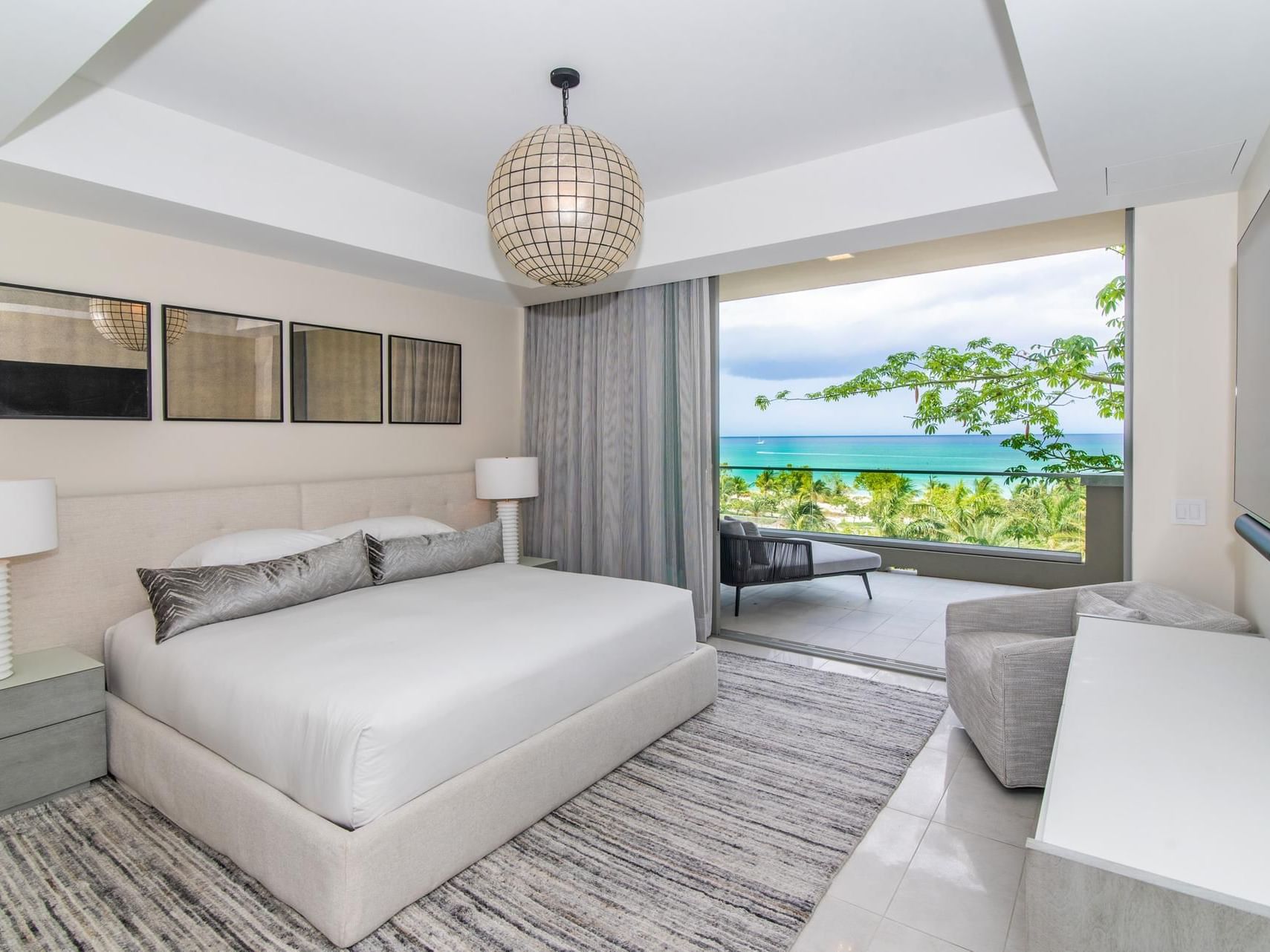 S301 Room with a large bed, stylish decor, and a stunning ocean view from the balcony in The Residences at Seafire.