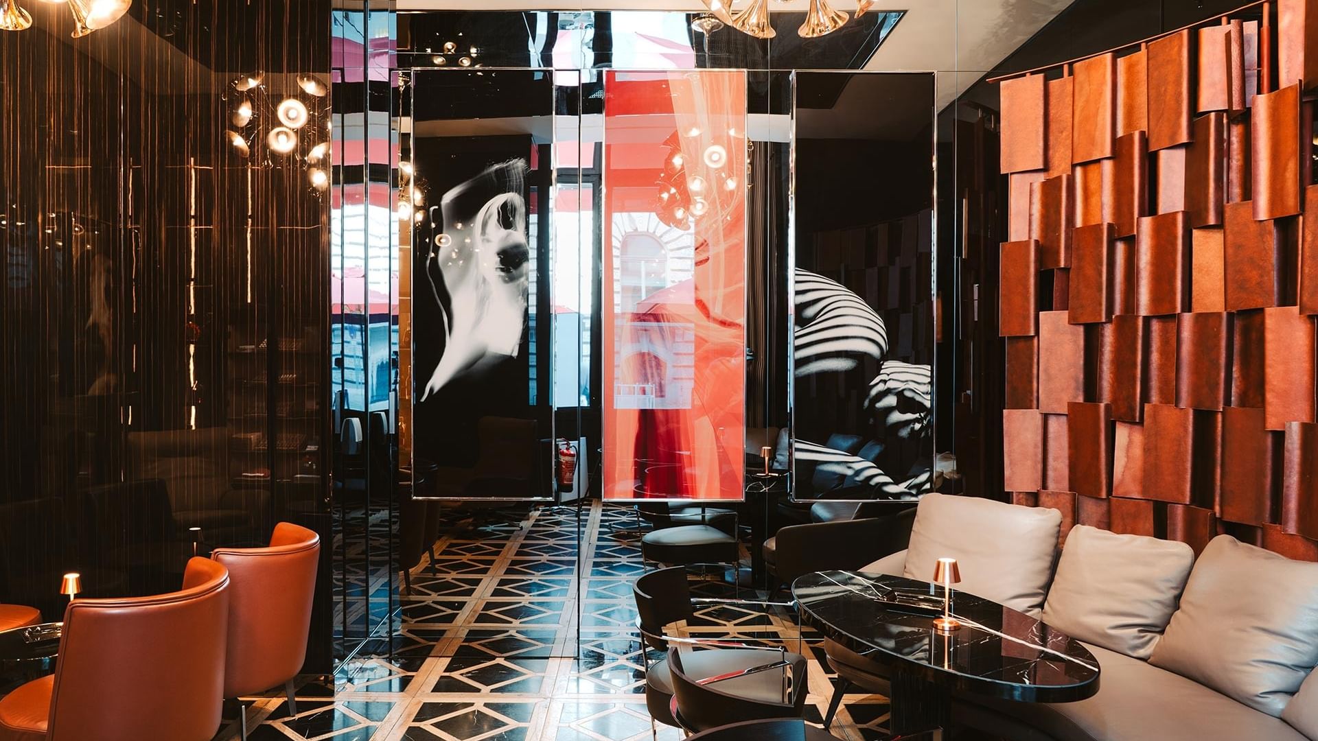 Moderne Lounge mit orangefarbenen Sesseln, Kunstwerken und geometrischem Boden im Titanic Gendarmenmarkt Berlin