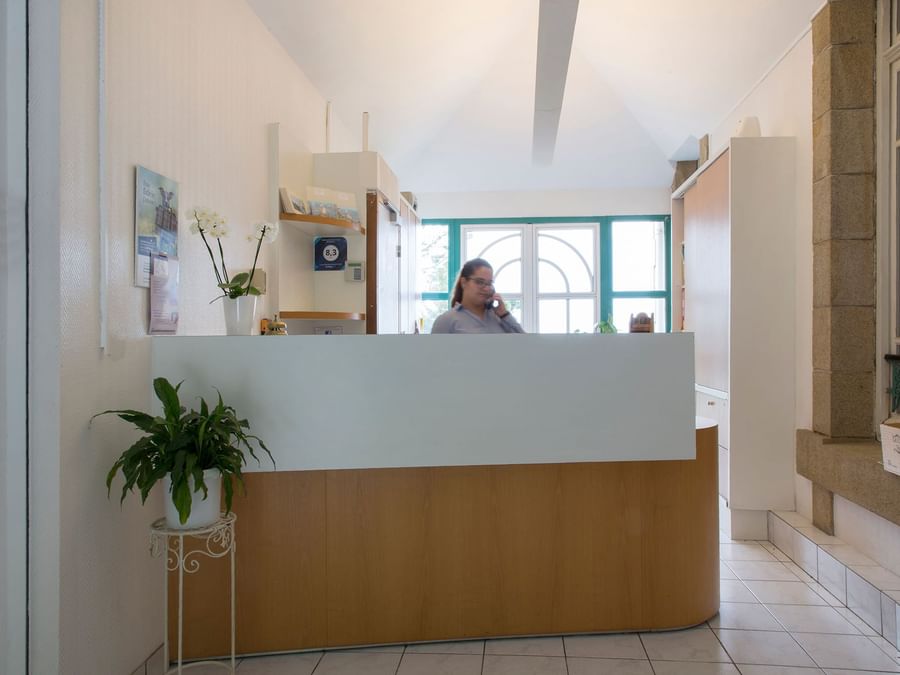 A receptionist at the reception desk in Clos de Vallombreuse