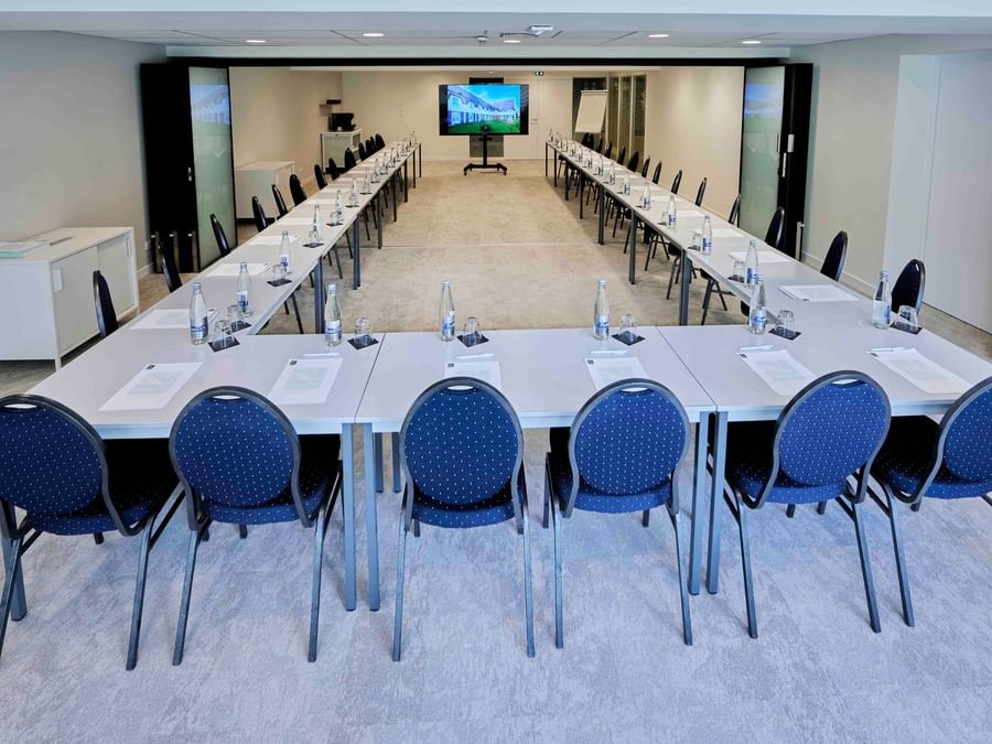 Salle de réunion bien équipée avec chaises et tables à l'Hôtel La Marébaudière.