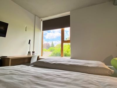 Work desk facing bed by the window in the Premium Double Room at Avaneo Hotel, one of the best room service hotels