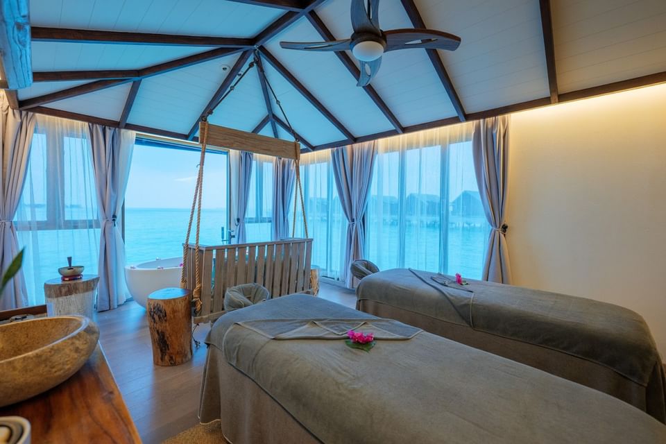 Two massage beds in a spa overlooking the ocean at Grand Park Kodhipparu