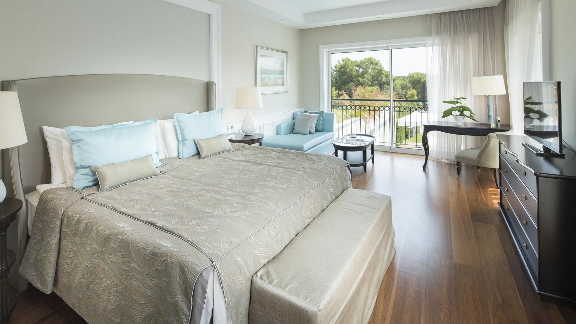 Titanic Deluxe Golf Belek'teki ahşap zeminli Design Pool Villa'da yatak yanında oturma alanı.