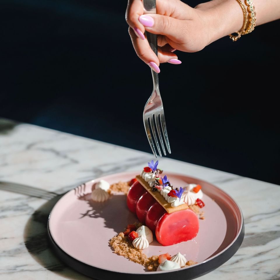 A fork about to slice into a beautifully plated dessert