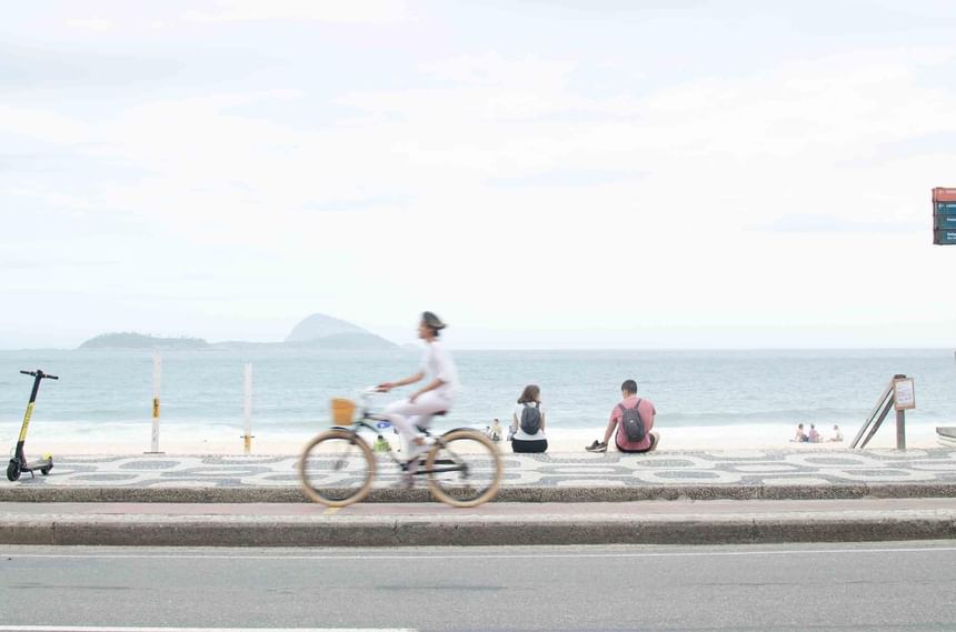 Man cycling down a coastal street near Janeiro Hotel