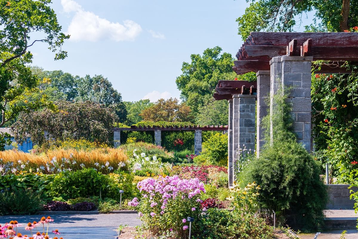 Lush botanical gardens with stone pergolas near Warwick Le Crystal Montreal