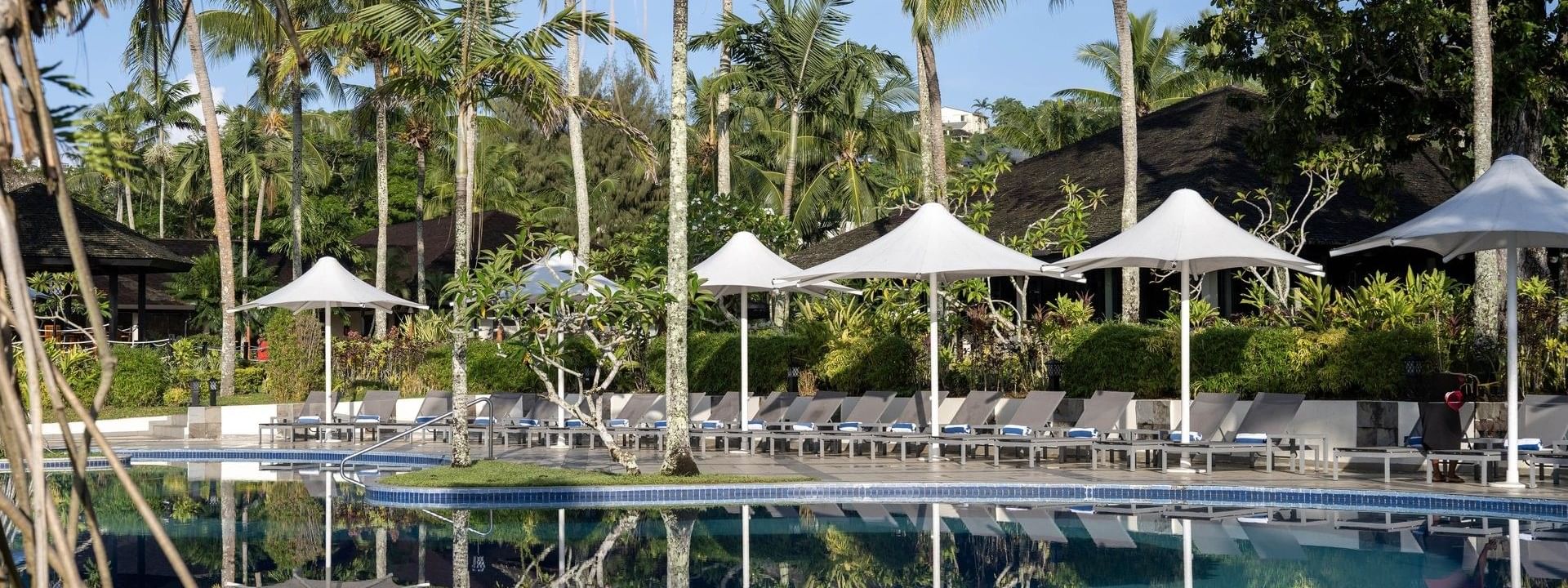 Pool and terrace beach area with loungers and umbrellas at Warwick Le Lagon - Vanuatu, Efate