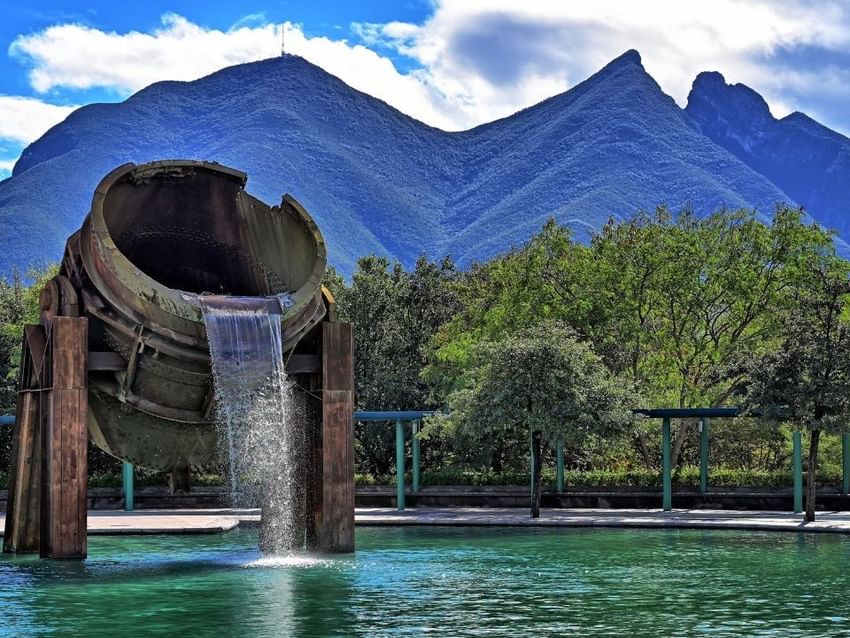 Fuente industrial con montañas del Cerro de la Silla al fondo cerca de Camino Real Hotels
