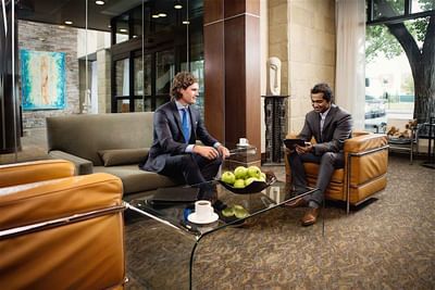 Two men discussing plans in a lounge at Metterra Hotel on Whyte