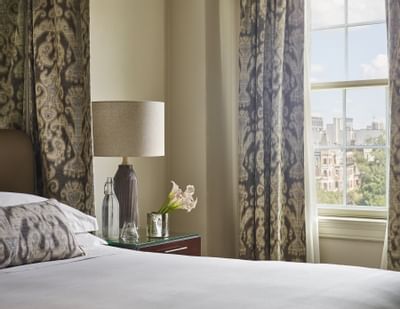 King bed & a nightstand in a bedroom of a suite at Eliot Hotel