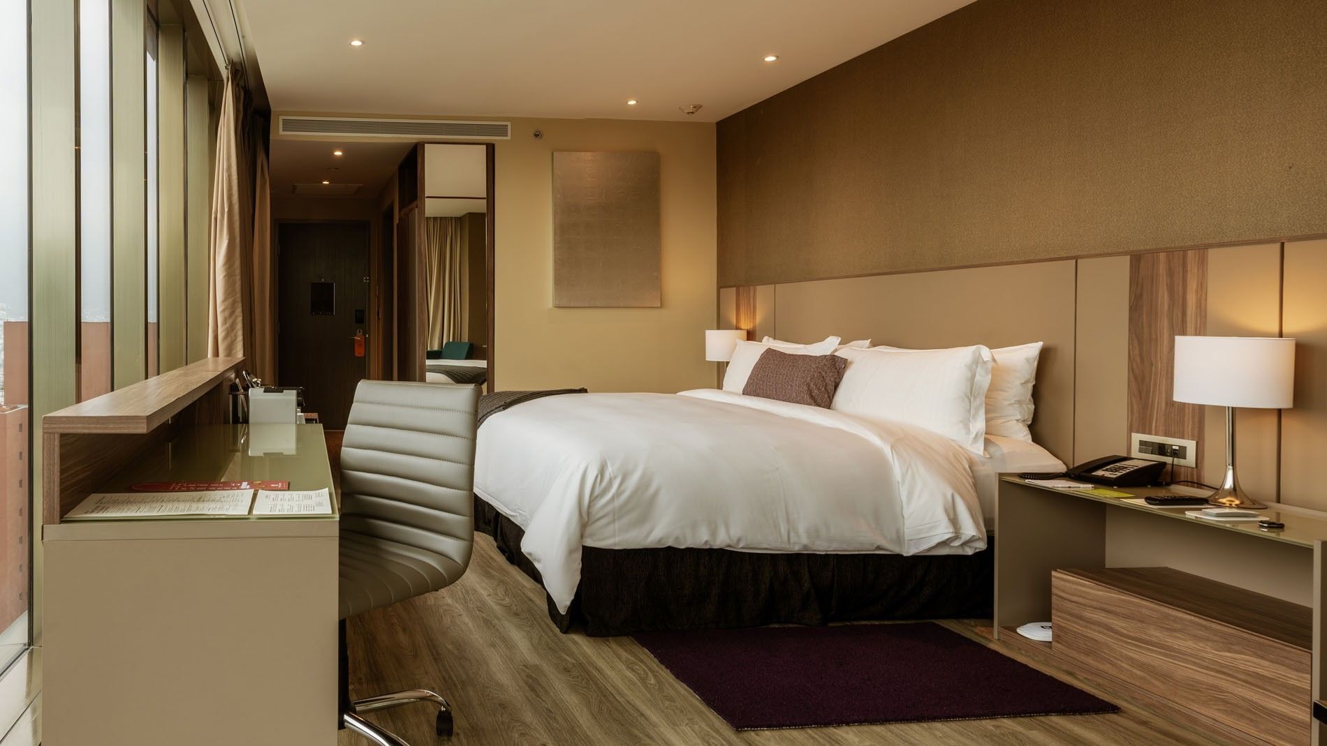 Superior Luxury King with a large bed, desk, office chair & floor-to-ceiling mirror at Camino Real Fashion Drive, Monterrey