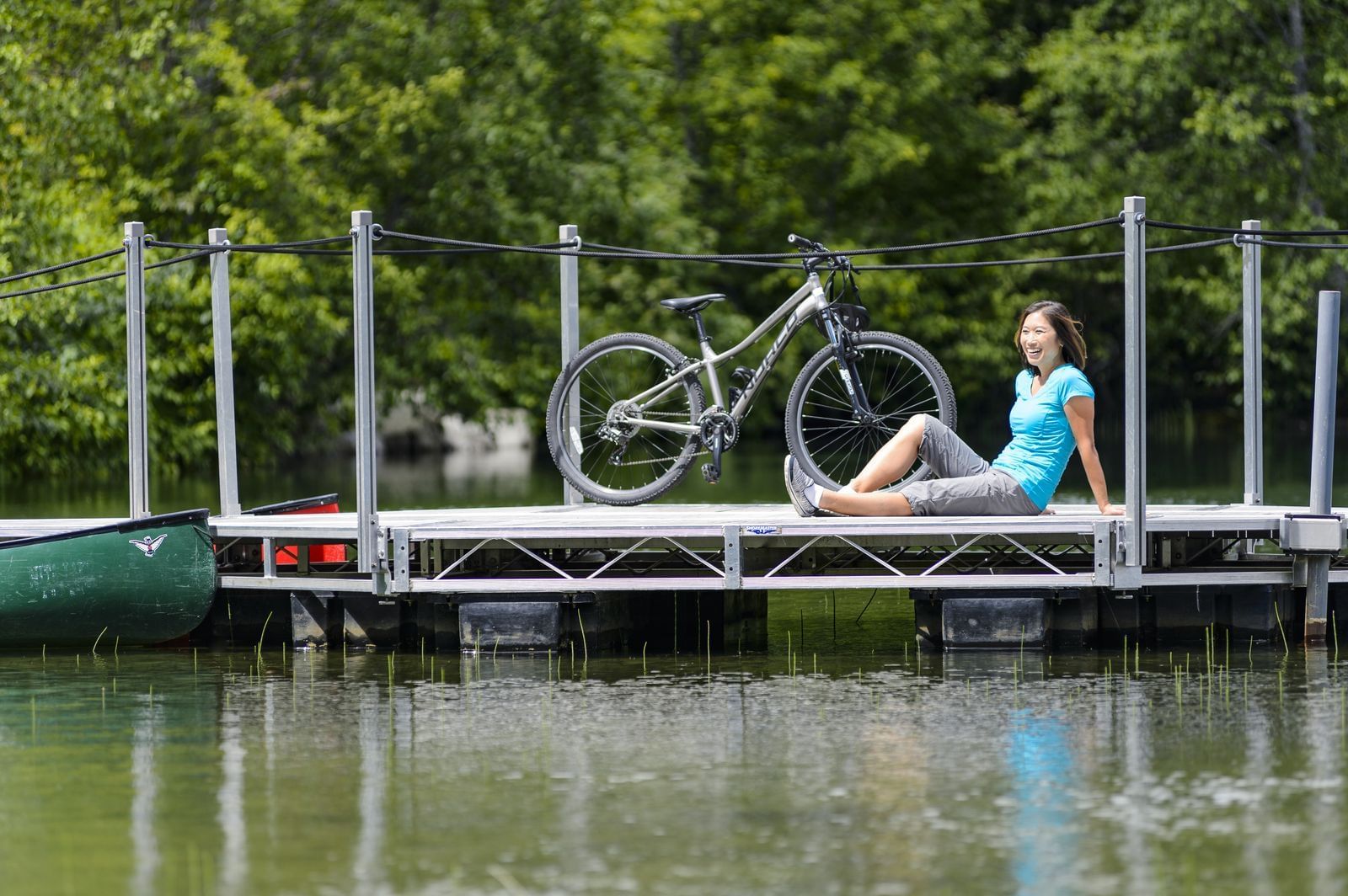 Lady sitting by a bicycle on a dock at Nita Lake Lodge