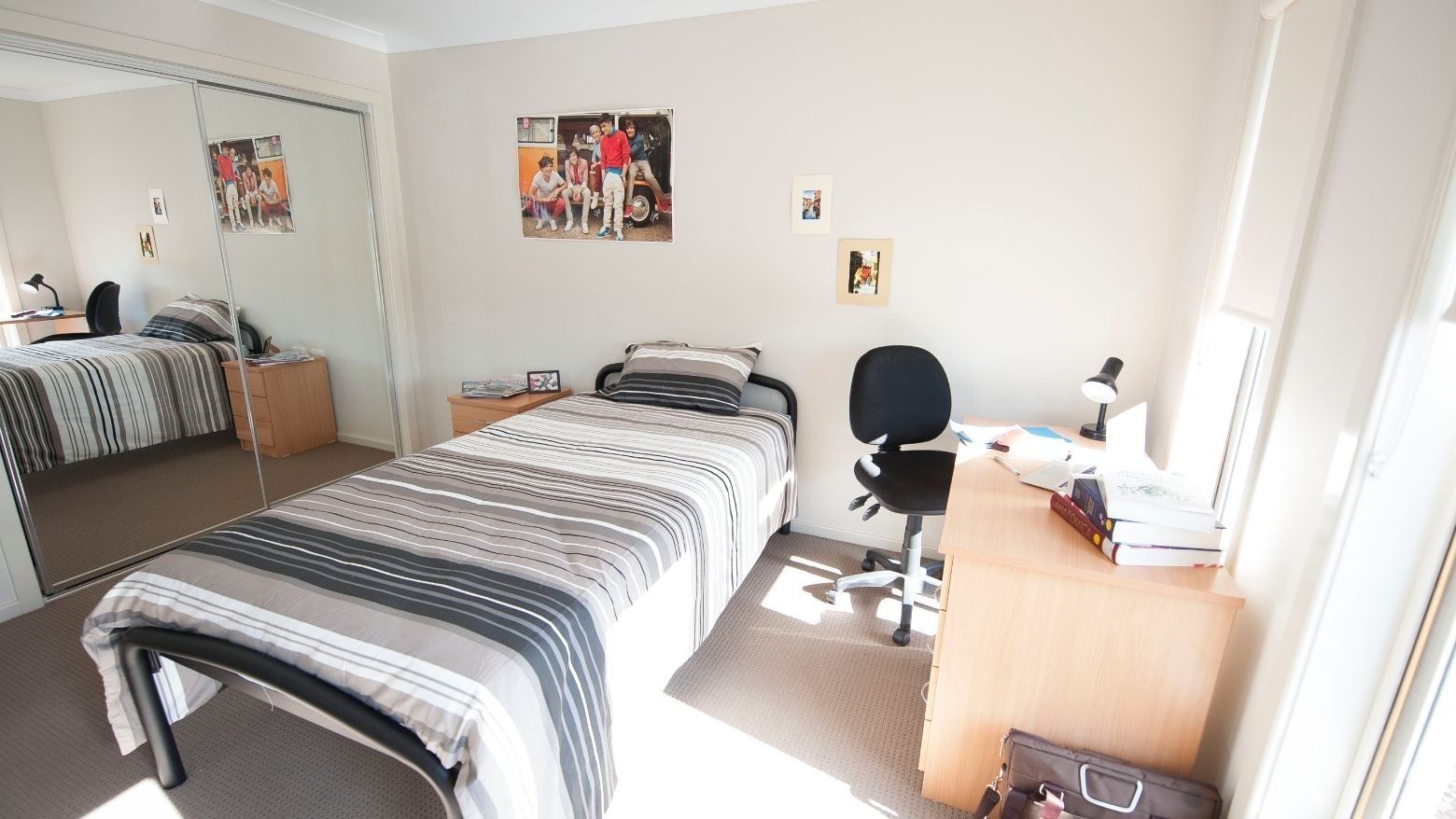 A neat single room with a bed, desk, and chair at La Trobe University Regional Housing Shepparton.