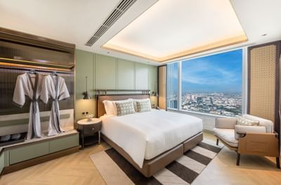 King bed, sofa & bathrobes in a suite at Eastin Grand Hotel Phayathai