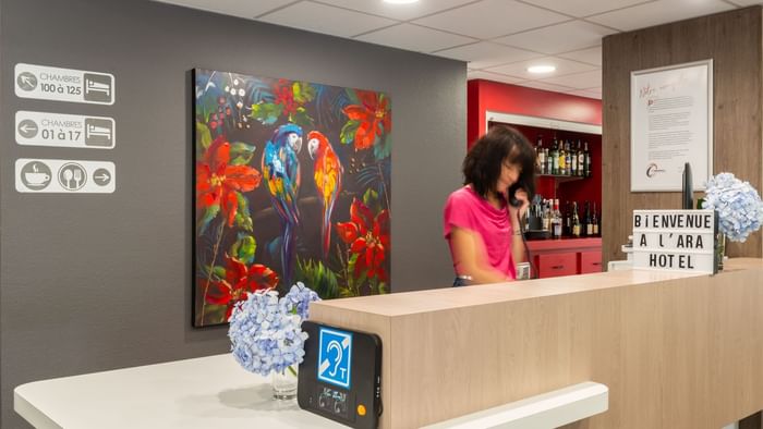 A receptionist at the reception desk in Ara Hotel