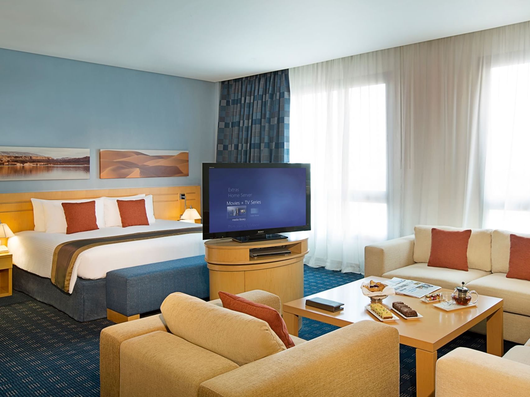 Bed & TV lounge area in Junior Suite at City Seasons Hotels