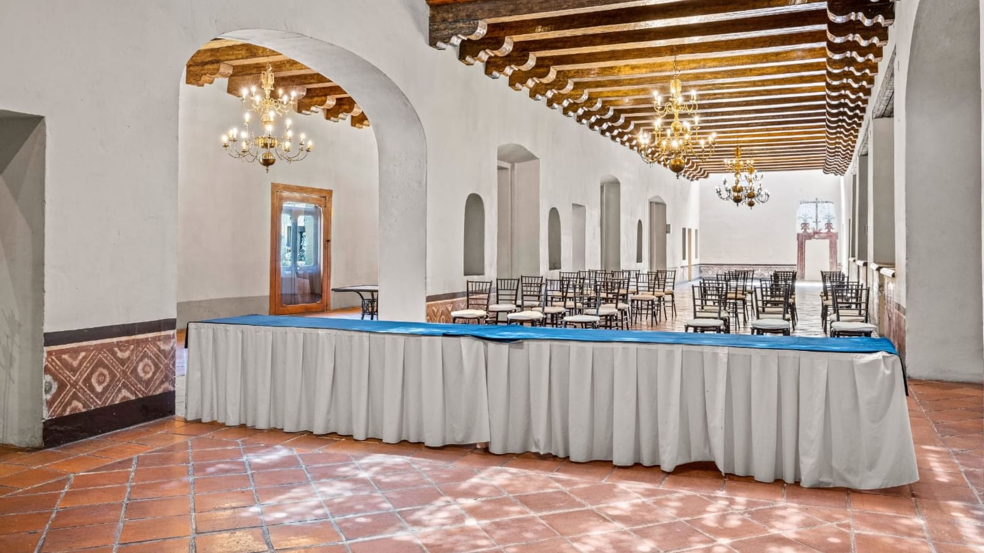 Long table with white and blue cloth in the Real de María event room at Quinta Real Puebla, Heroica Puebla de Zaragoza.