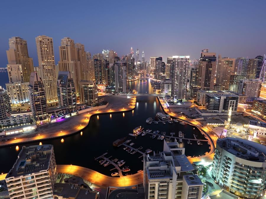 Twilight view of a marina with skyscrapers near DAMAC Maison Aykon City, the best luxury hotel in Dubai