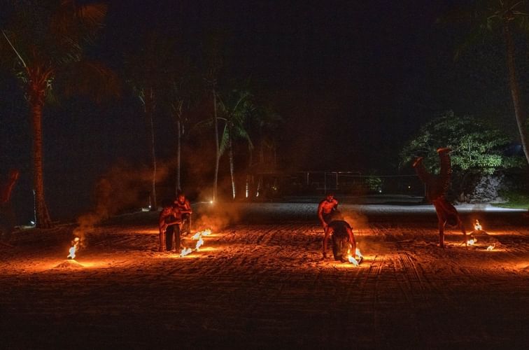 Performers on a dark beach at night, using fire torches to create a dramatic spectacle near warwick le lagon-vanuatu