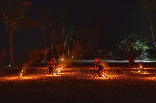 Performers on a dark beach at night, using fire torches to create a dramatic spectacle near warwick le lagon-vanuatu