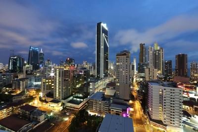 Twilight cityscape with illuminated skyscrapers against a dusk sky near MARlNN Place Financial District