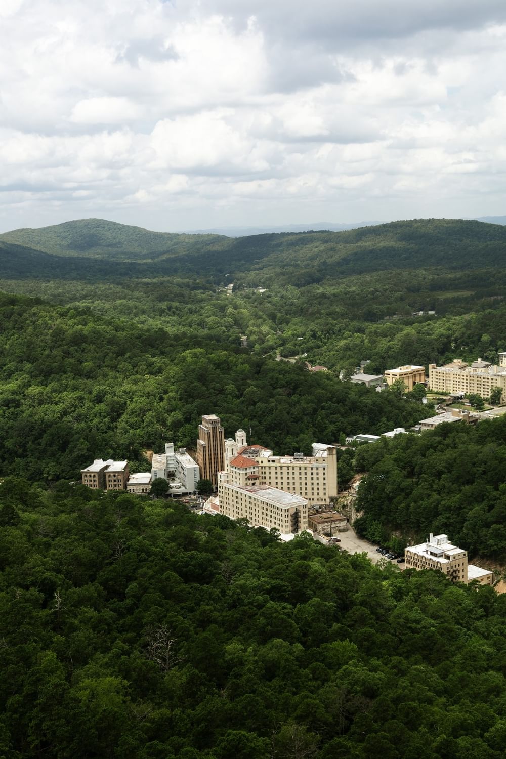 Lush green valley by forest hills under a cloudy sky surrounding Arlington Resort Hotel & Spa