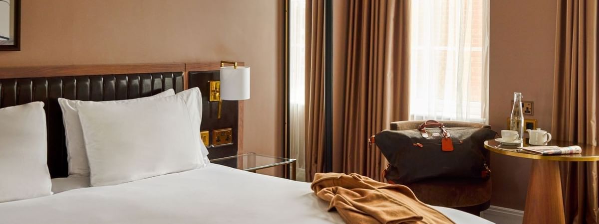 Elegant room with bed, chair, and table under the Plan a Little, Save a Lot offer.