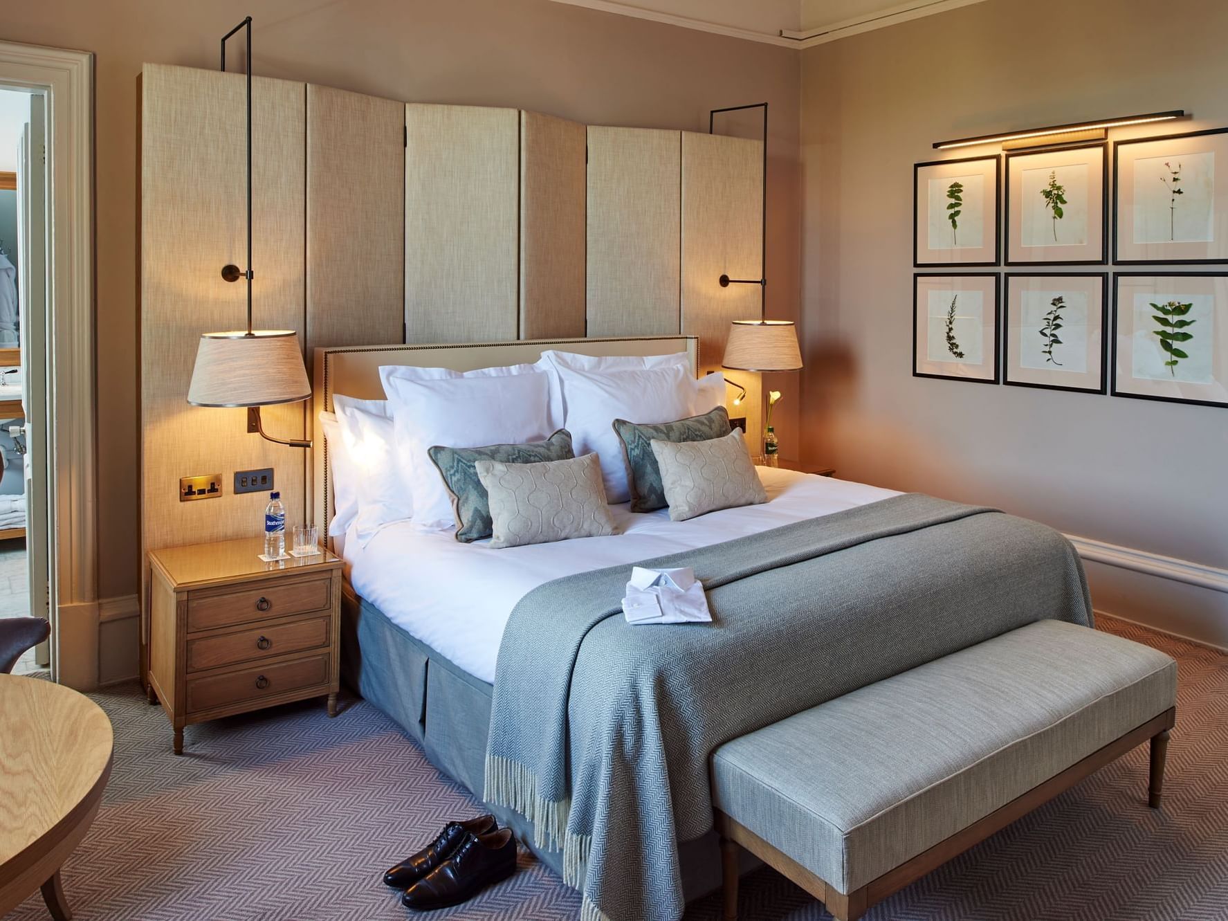 Bedroom with a bed, side tables, lamps, and botanical art on the wall at The Milner York