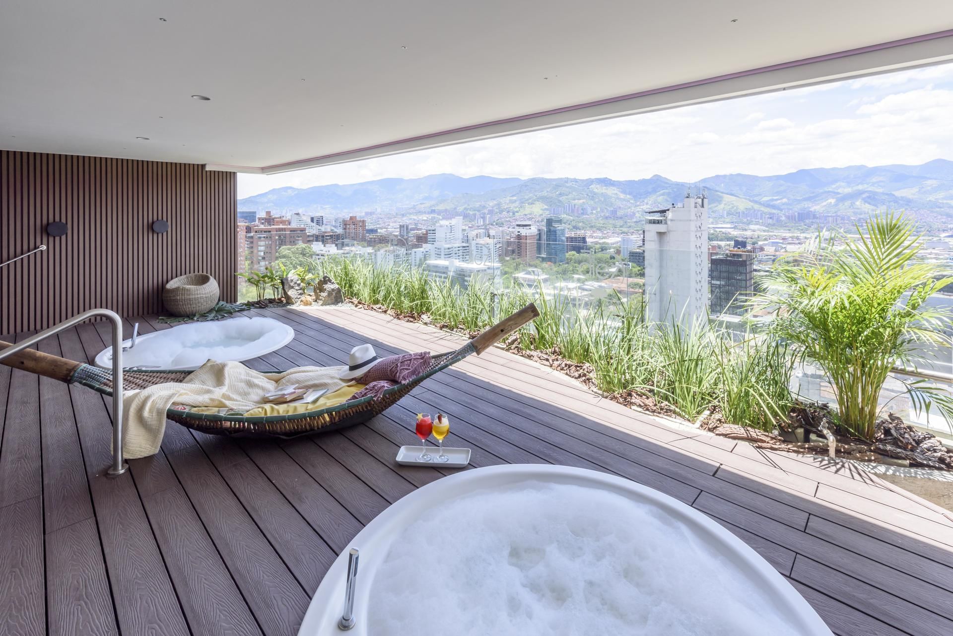 A hot tub on a wooden deck with city view, Diez Hotel Categoría