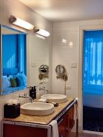 Salle de bains moderne avec double vasque et grand miroir au Warwick Le Crystal – Montréal.