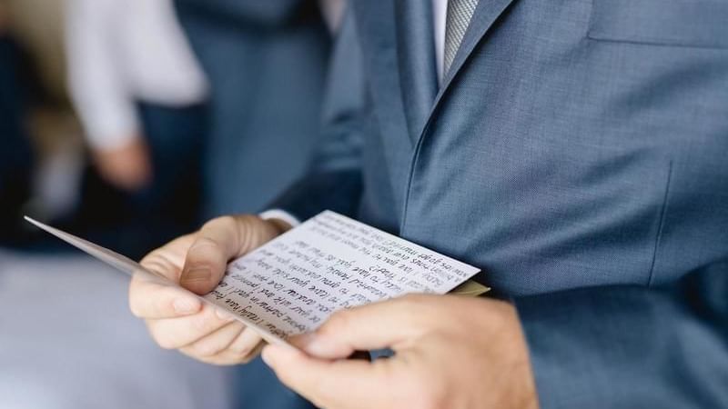 Man in suite reading a wedding card at FA acapulco villas