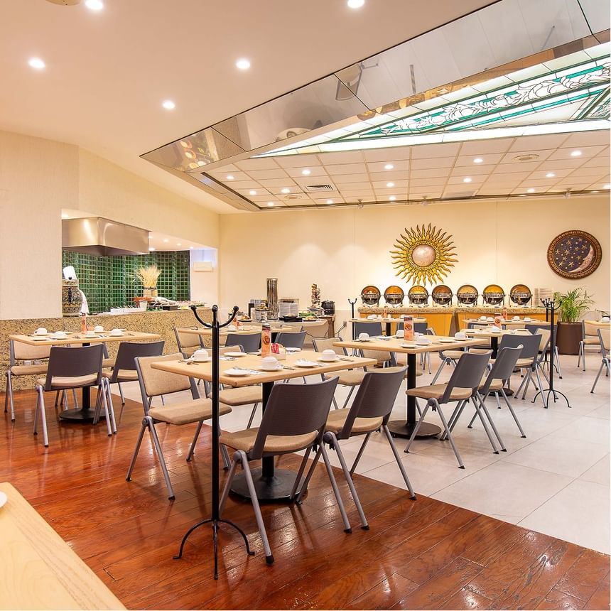 Sala de comedor elegante con mesas y sillas en Hotel Guadalajara Plaza Expo