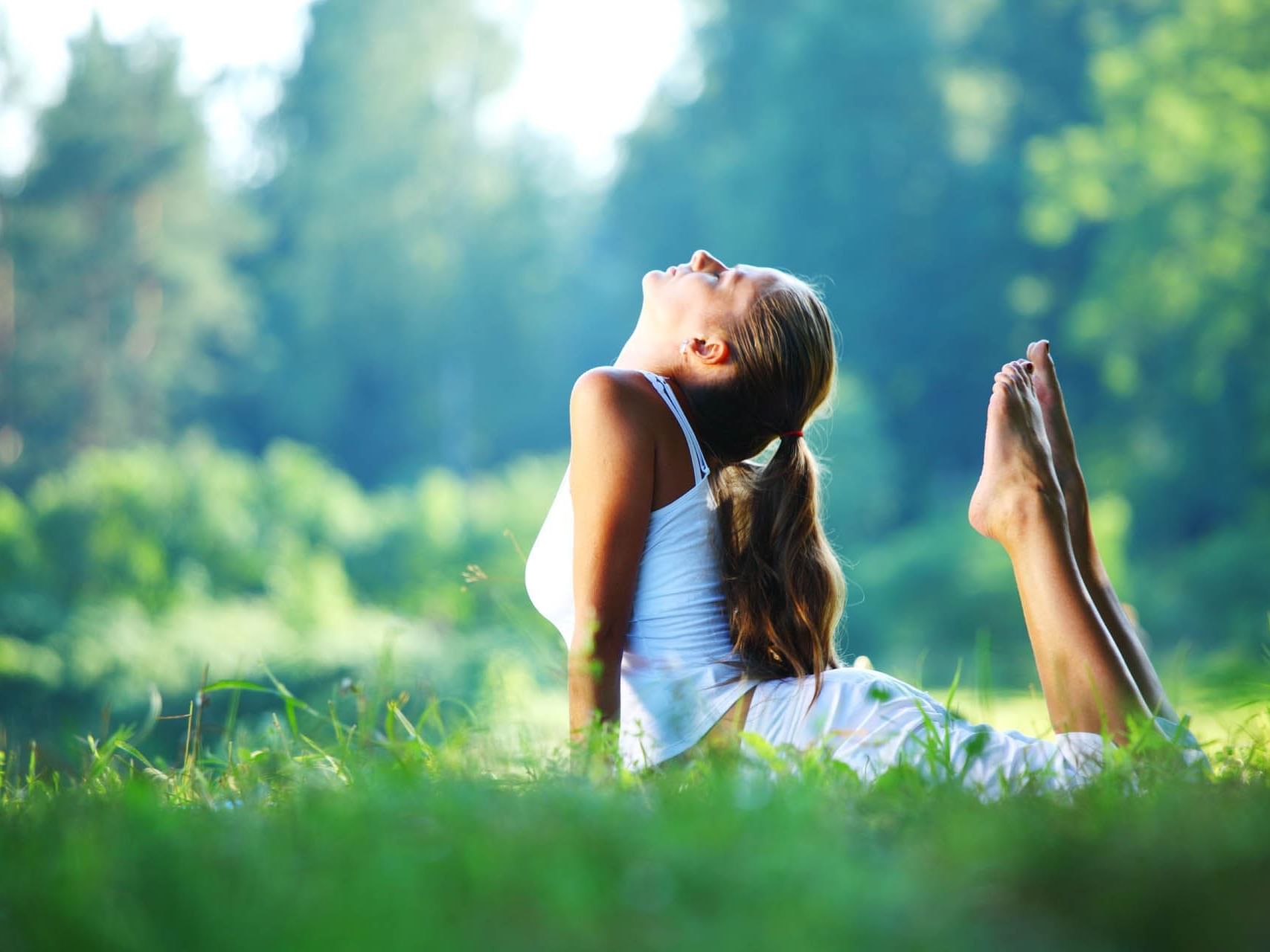 Girl doing Yoga on the grassy ground near Honor's Haven Retreat