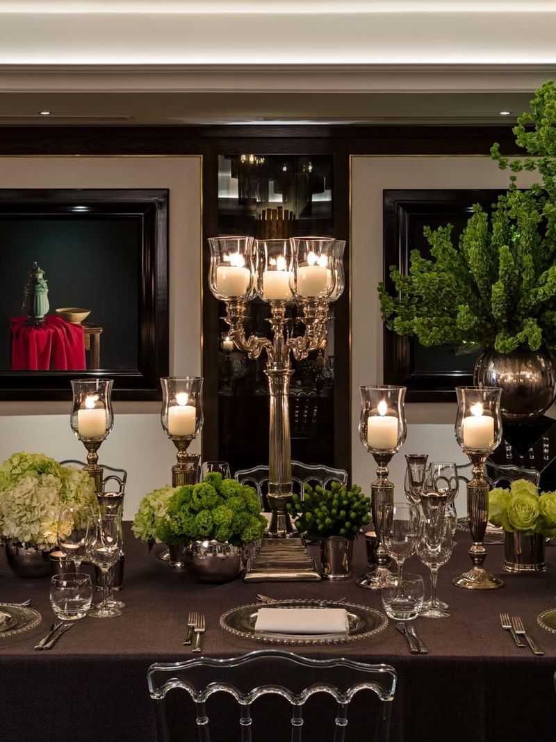 An elegantly set dining table with floral arrangements and candleholders at The May Fair Hotel London.