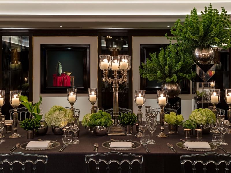 An elegantly set dining table with floral arrangements and candleholders at The May Fair Hotel London.