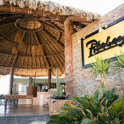 The welcoming entrance of Pitahayas restaurant at Hacienda del Mar Los Cabos, with a large palapa roof