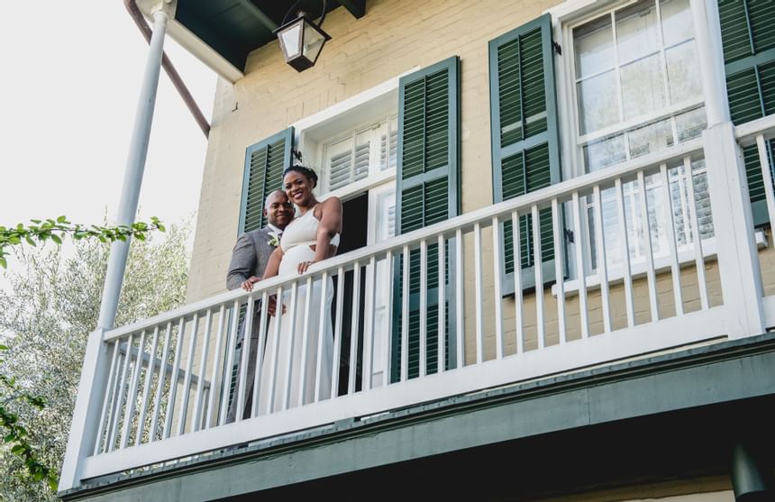 A bride and groom on the balcony at Audubon Cottage