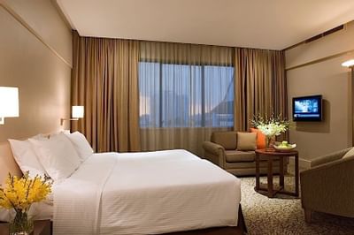 TV lounge area by the bed in York Suite with carpeted floors at York Hotel Singapore