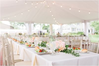 Elegant outdoor tent with tables, gold chiavari chairs, and pink floral centerpieces at Aramark Chauncey Conference Center