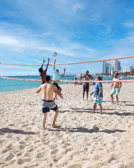 Group of people playing volleyball in beach near Plaza Pelicanos Club Beach Resort